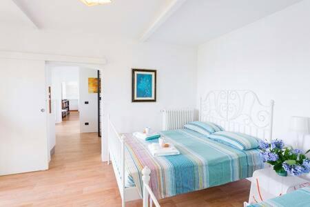 a white bedroom with a bed and a hallway at Villa Arona in Arona