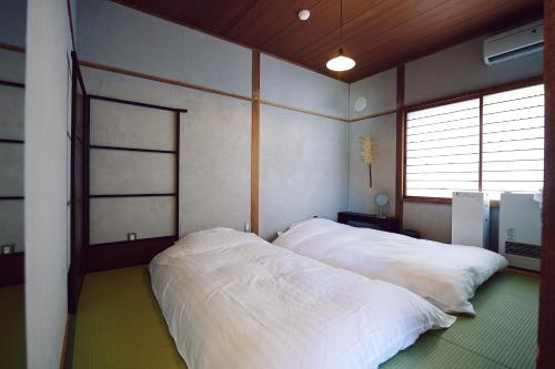 1 dormitorio con 2 camas blancas en SMALL TOWN HOTEL Hakodate, en Hakodate