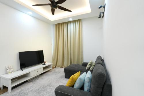 a living room with a couch and a flat screen tv at Flat in Cyberjaya 2R 2BR 5 mins driving to Tamarind Square in Cyberjaya