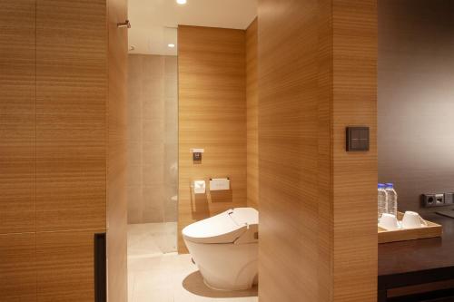a bathroom with a toilet and wooden walls at Crown Park Hotel Seoul Myeongdong in Seoul