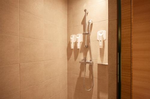 a bathroom with a shower with a phone on the wall at Crown Park Hotel Seoul Myeongdong in Seoul