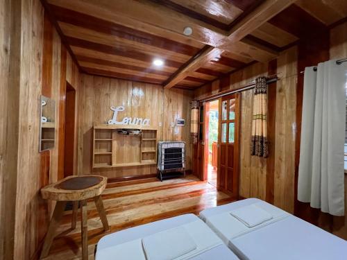 a living room with wood paneling and a table and a couch at Ozar Homestay in Mambajao