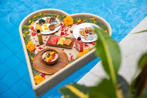 The Luxury Collection, Monaco Blu في سمينياك: طاولة عليها طعام بجوار حمام سباحة