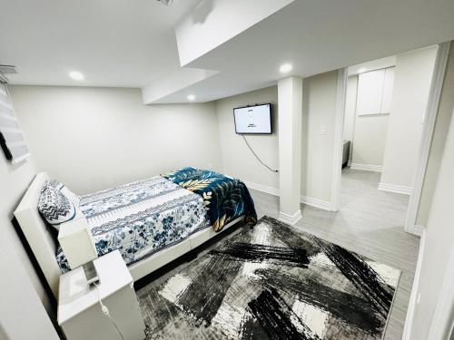 a bedroom with a bed and a tv on a wall at C&M Beautiful Basement in Brampton