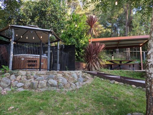 a garden with a gazebo and a picnic table at Littlehurst Lodge in Millgrove