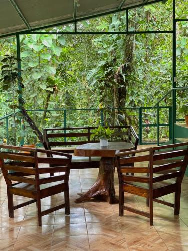 a table and two benches in front of a tree at Campo Verde House, La Fortuna de San Carlos in Fortuna