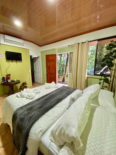 a large white bed in a room with a window at Campo Verde House, La Fortuna de San Carlos in Fortuna