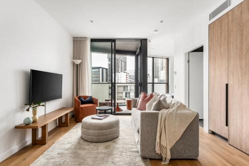 a living room with a couch and a tv at Urban Rest Parramatta Apartments in Sydney
