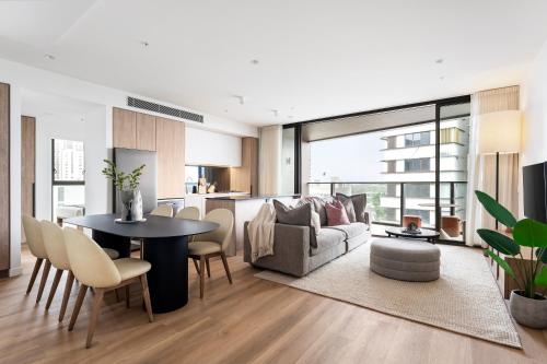 a living room with a table and a couch at Urban Rest Parramatta Apartments in Sydney