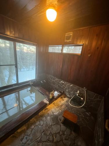 baño con lavabo de piedra y ventana en 源泉掛け流し付き貸切別荘-Authentic private home with Private Kusatsu Onsen - THE HIDEOUT VILLA KUSATSU- en Kusatsu