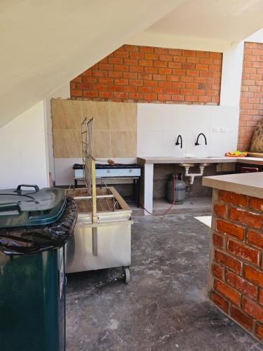 a kitchen with a counter and a brick wall at Miski Rumi. in Huaycán Alto