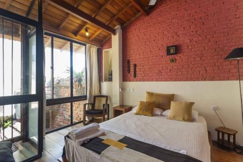 um quarto com uma cama e uma parede de tijolos vermelhos em Highbury Colombo em Colombo
