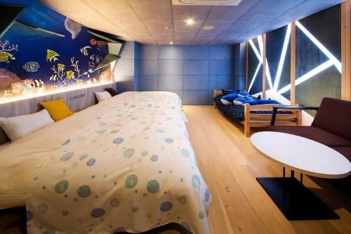 a bedroom with a large bed and a couch at リゾートホテル美萩 in Hagi