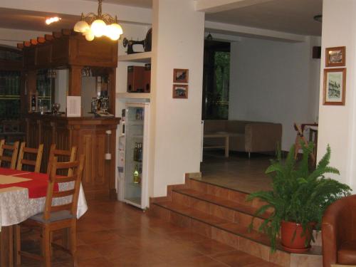 a kitchen and living room with a table and a dining room at Pensiunea Comarnic-Moisa in Comarnic