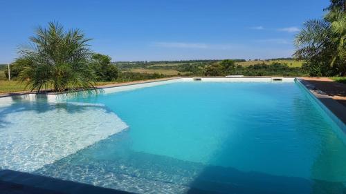 uma grande piscina com água azul em Tropische Träume em Doctor Juan Manuel Frutos