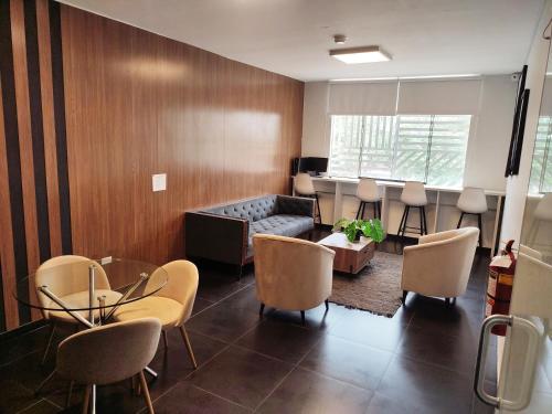 a living room with a couch and a table and chairs at Rua Hoteles Piura in Piura