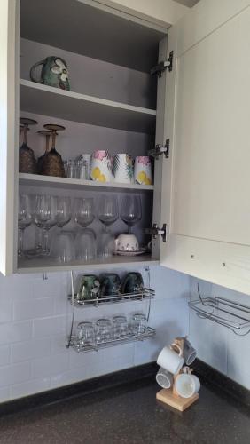 a kitchen with a cupboard with glasses and dishes at Haumok52 Udo in Jeju