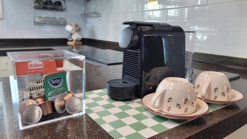 a kitchen counter with a coffee maker and two dishes at Haumok52 Udo in Jeju