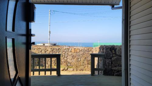 an open door of a building with a stone wall at Haumok52 Udo in Jeju