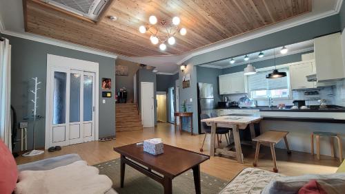 a living room with a table and a kitchen at Haumok52 Udo in Jeju