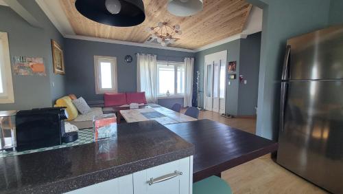 a kitchen and living room with a stainless steel refrigerator at Haumok52 Udo in Jeju