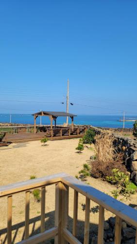 a view of a beach with a picnic table and the ocean at Haumok52 Udo in Jeju