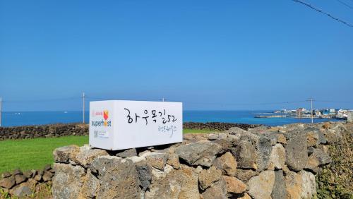 a sign sitting on top of a rock wall at Haumok52 Udo in Jeju