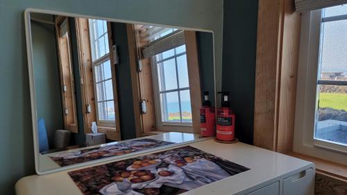 a mirror sitting on a counter in a room with windows at Haumok52 Udo in Jeju