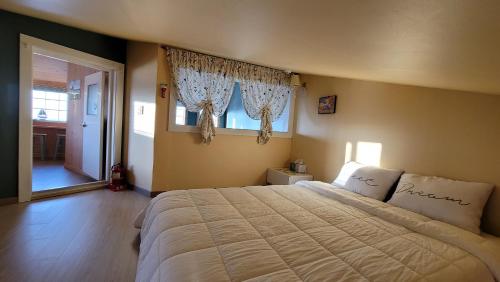a bedroom with a large bed and two windows at Haumok52 Udo in Jeju