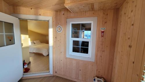 a room with wooden walls and a window and a bed at Haumok52 Udo in Jeju