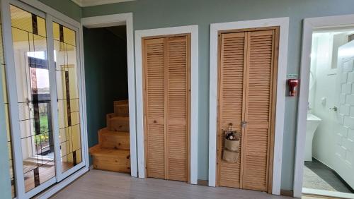 two wooden doors in a room with stairs at Haumok52 Udo in Jeju