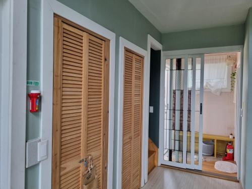 a hallway with wooden doors in a house at Haumok52 Udo in Jeju
