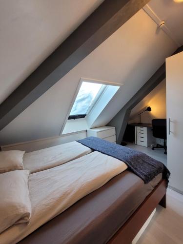 een slaapkamer met een groot bed en een raam bij Cozy 2bdr apt. 3 min walk to Solsiden in Trondheim