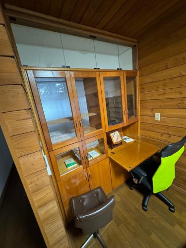 an office with a wooden desk and a green chair at 源泉掛け流し付き貸切別荘-Authentic private home with Private Kusatsu Onsen - THE HIDEOUT VILLA KUSATSU- in Kusatsu