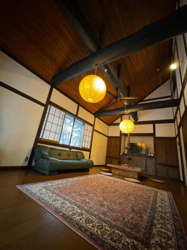 草津町にある源泉掛け流し付き貸切別荘-Authentic private home with Private Kusatsu Onsen - THE HIDEOUT VILLA KUSATSU-の広いリビングルーム(ラグ、照明2つ付)
