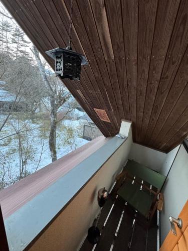 a room with a bench and a wooden ceiling at 源泉掛け流し付き貸切別荘-Authentic private home with Private Kusatsu Onsen - THE HIDEOUT VILLA KUSATSU- in Kusatsu