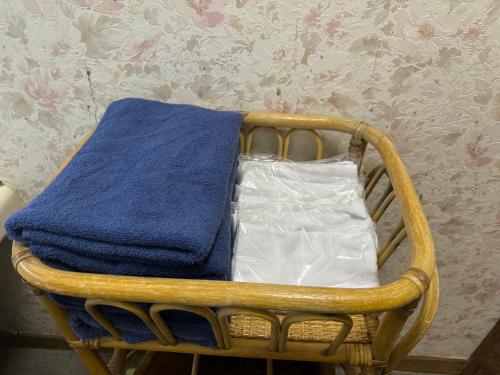 a wooden rocking chair with a blue towel on it at 源泉掛け流し付き貸切別荘-Authentic private home with Private Kusatsu Onsen - THE HIDEOUT VILLA KUSATSU- in Kusatsu