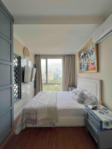 a bedroom with a bed and a large window at SWSB Home — 3BR Apartment in Jakarta City Centre in Jakarta