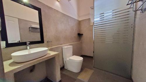 a bathroom with a sink and a toilet and a mirror at Villa Inlet Galle in Galle