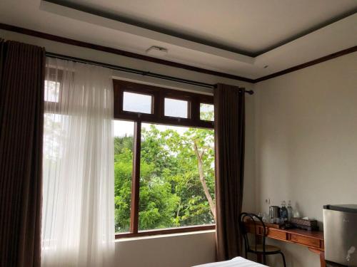 a bedroom with a window with a tree at Edge Resort, Yogyakarta in Parangtritis