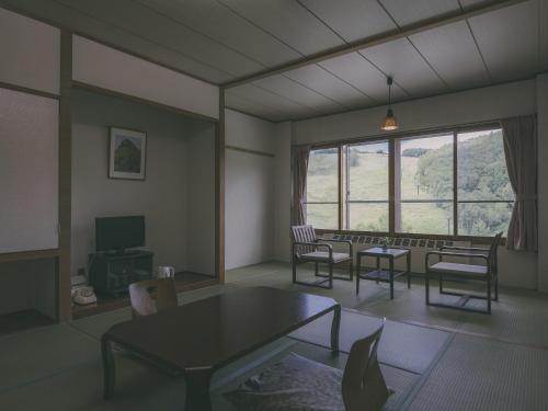 a living room with a table and chairs and a window at Chalet Shiga in Yamanouchi