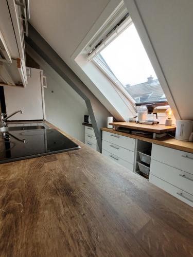 een zolderkeuken met een aanrecht en een raam bij Cozy 2bdr apt. 3 min walk to Solsiden in Trondheim