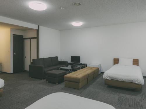 a hotel room with a bed and a couch at Chalet Shiga in Yamanouchi