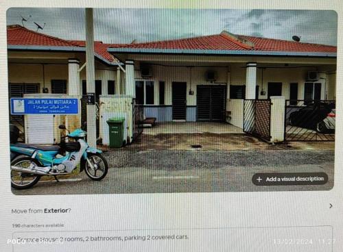 una motocicleta estacionada frente a una casa en Sorry, Blocked Account, en Temerloh