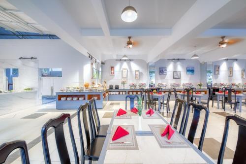 a restaurant with tables and chairs with red napkins at Ocean Pearl Hotel Phu Quoc in Phu Quoc