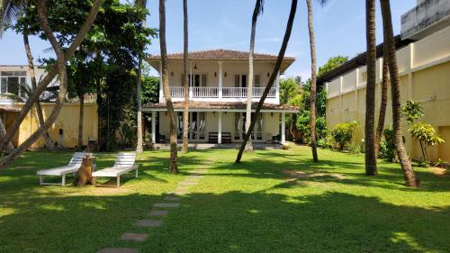 a house with a dog sitting in the yard at Villa Inlet Galle in Galle