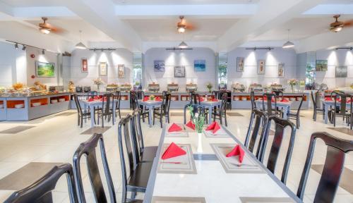 a restaurant with tables and chairs with red napkins at Ocean Pearl Hotel Phu Quoc in Phu Quoc