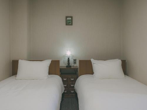 two beds sitting next to each other in a room at Chalet Shiga in Yamanouchi