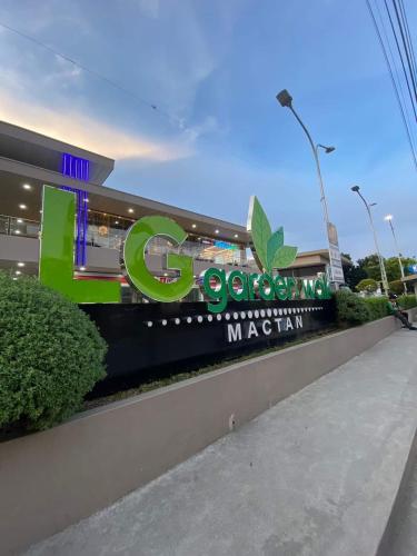 a building with a green sign in front of it at Mactan Newtown Beach Condo in Mactan