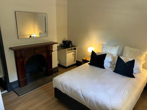 a bedroom with a bed with a fireplace and a mirror at The Rec Hotel Waroona in Waroona
